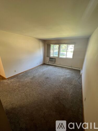 A room with a carpeted floor and a window.