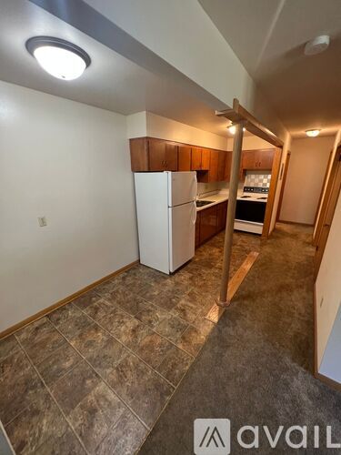 A kitchen area with a refrigerator, oven, and cabinets.