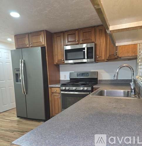 A kitchen with a refrigerator, stove, and microwave.