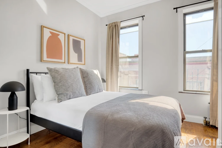 A bedroom with a large bed and two picture frames on the wall.