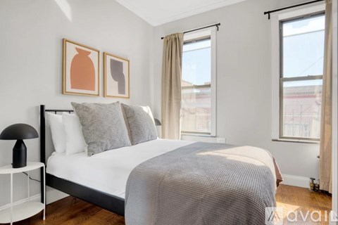 A bedroom with a large bed and two picture frames on the wall.