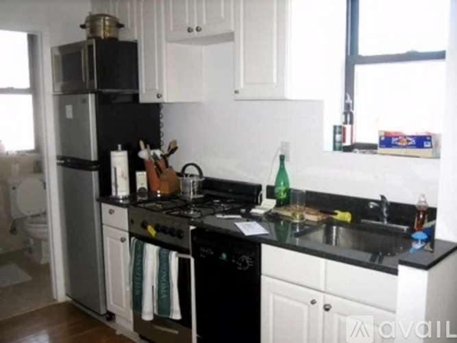 A kitchen with black countertops and white cabinets.