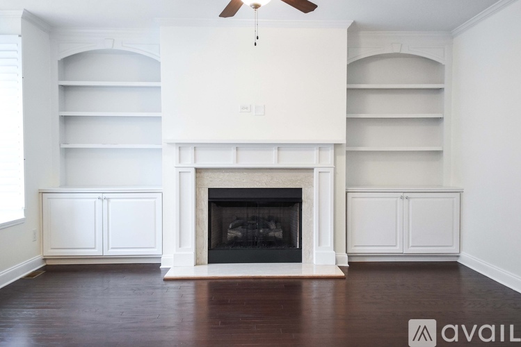 A living room with a fireplace and a fan.