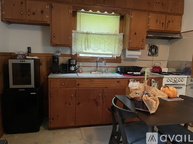 A kitchen with wooden cabinets and a black fridge.