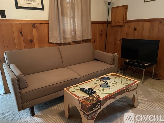 A tan couch sits in a living room with a coffee table in front of it.