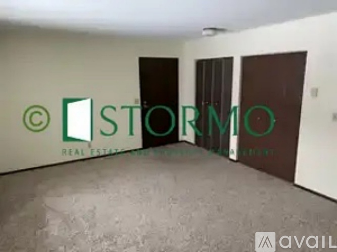 A room with a sign that says "STORMO REAL ESTATE" on the wall.