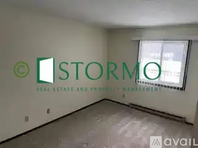 A room with a sign that says "STORMO REAL ESTATE AND PROPERTY MANAGEMENT".
