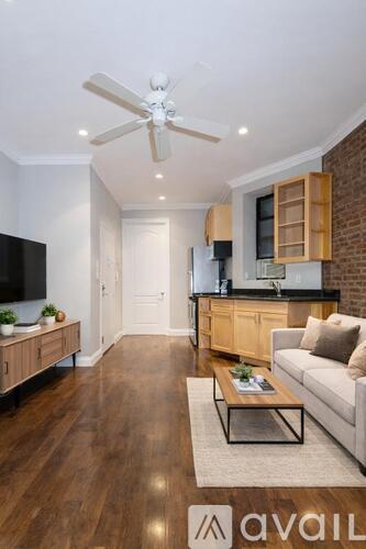 A modern living room with a wooden floor and a ceiling fan.