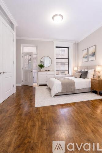 A bedroom with a large bed and wooden floors.