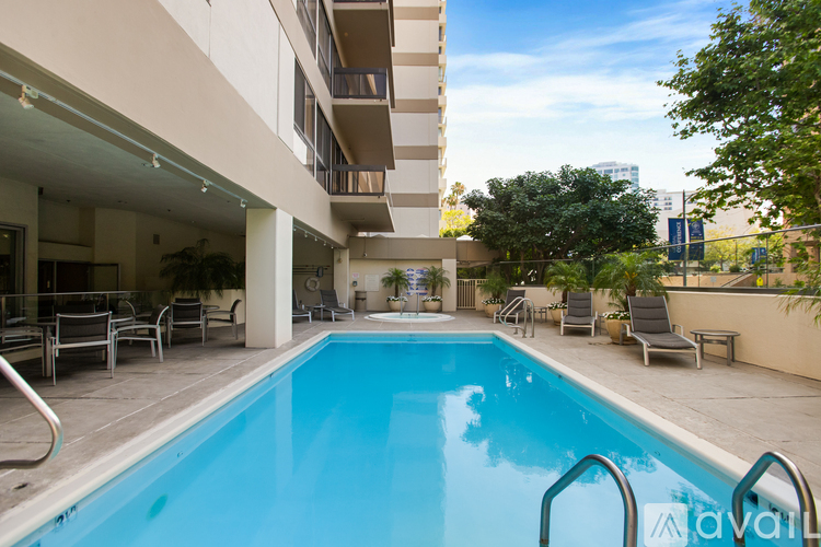 A pool in a residential area with chairs around it.