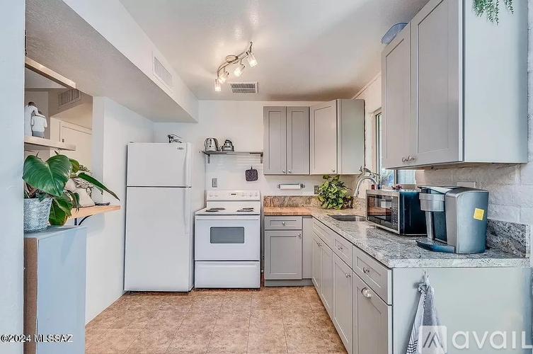 A kitchen with white appliances and cabinets.