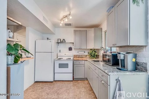 A kitchen with white appliances and cabinets.