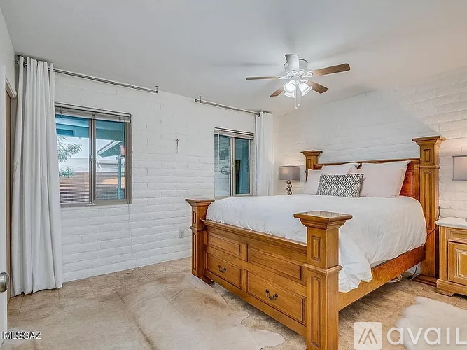 A bedroom with a bed, nightstand, and window.