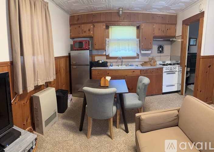 A kitchen with a table and chairs in the middle.