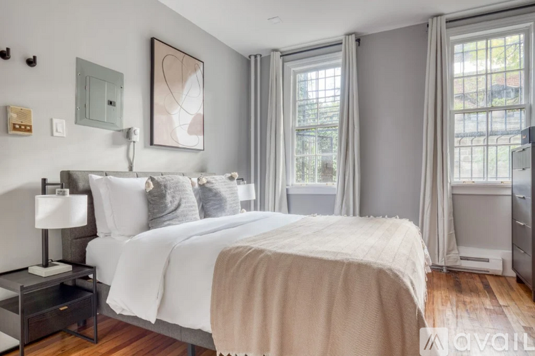 A bedroom with a large bed and a nightstand with a lamp.