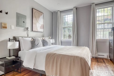 A bedroom with a large bed and a nightstand with a lamp.