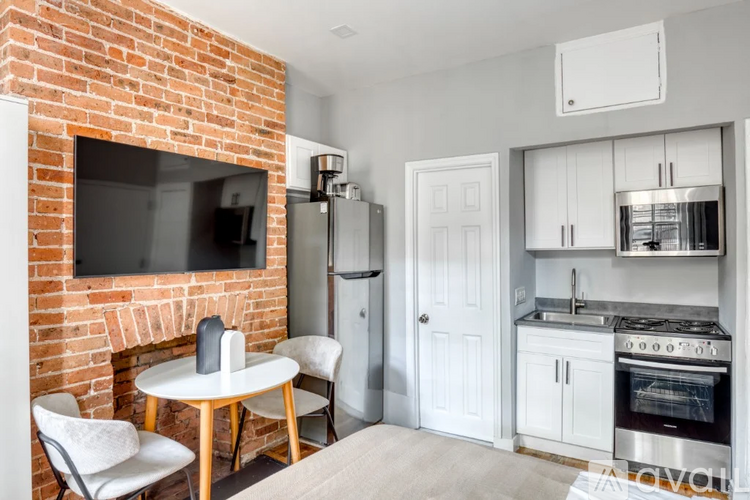 A kitchen with a brick wall and a white table.