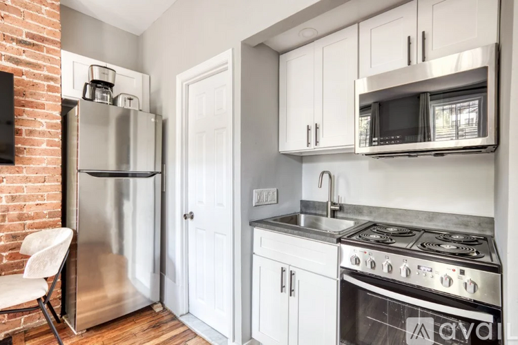A kitchen with a refrigerator, oven, and microwave.