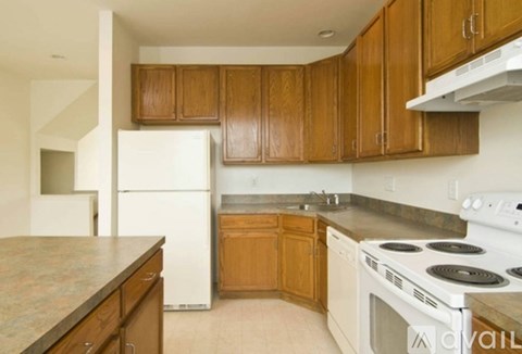 A kitchen with wooden cabinets and a white refrigerator.