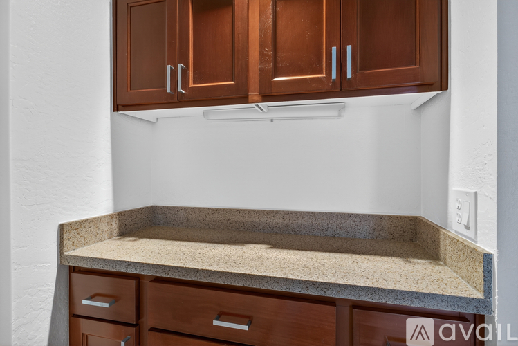 A kitchen counter with a granite top and wooden drawers underneath.