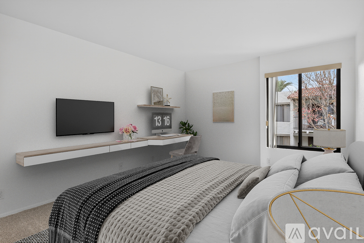 A bedroom with a large bed and a flat screen TV mounted on the wall.
