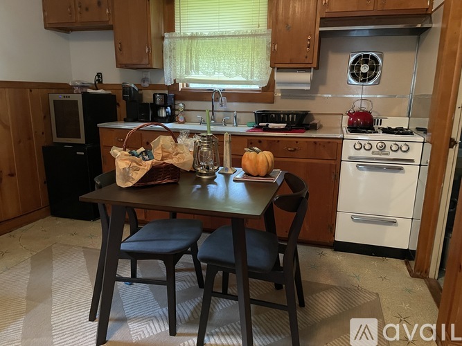 A kitchen with a table and chairs in front of a stove.