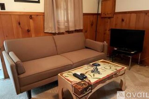 A tan couch sits in a living room with a coffee table in front of it.