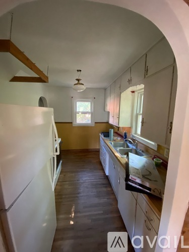 A kitchen with white appliances and wooden cabinets.