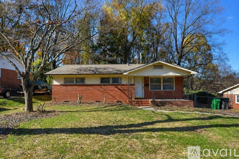 A house with a yellow roof is surrounded by trees and grass.