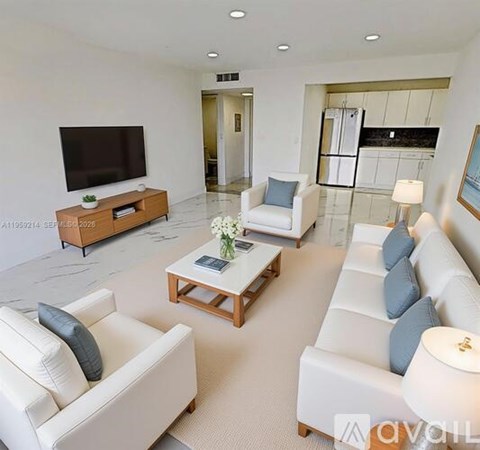 A living room with white furniture and a flat screen TV.