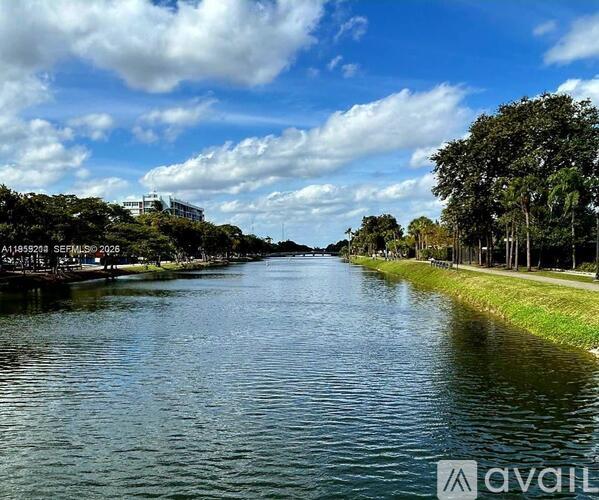 A river flows through a city with trees on the banks.
