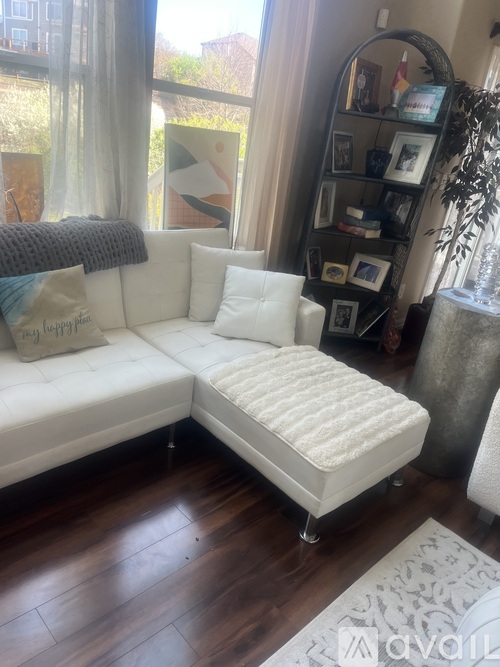 A white couch with a pillow that says Happy Birthday on it.