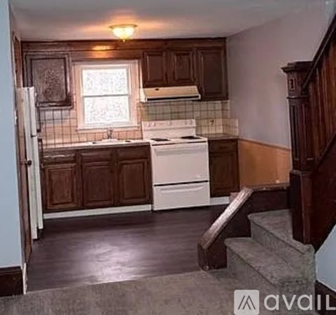 A kitchen with wooden cabinets and a white stove top oven.