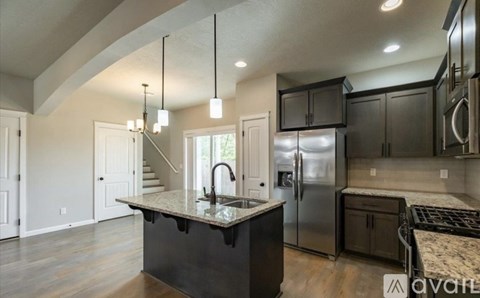 A modern kitchen with a center island and stainless steel appliances.