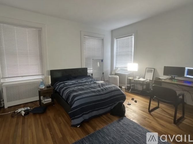 A bedroom with a bed, desk, and chair.
