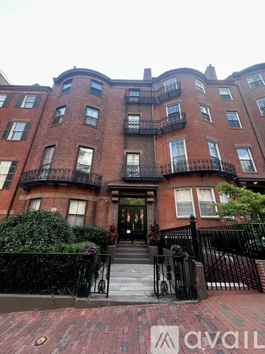 A brick building with a black gate in front.