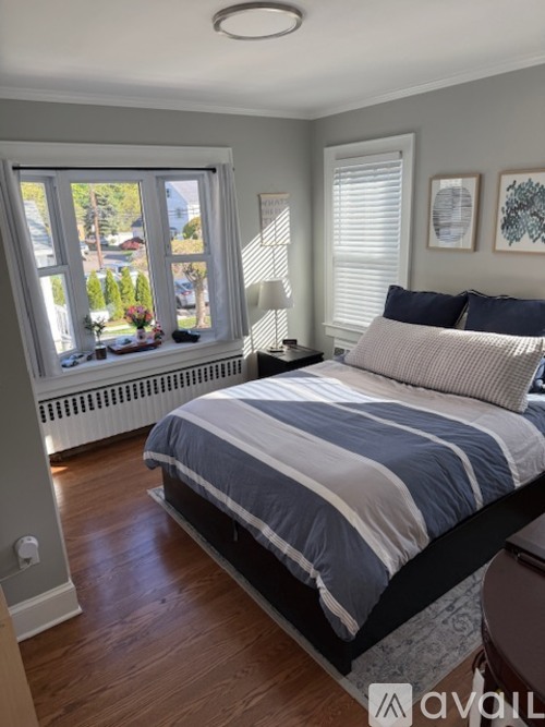 A bedroom with a large bed and a window overlooking a street.