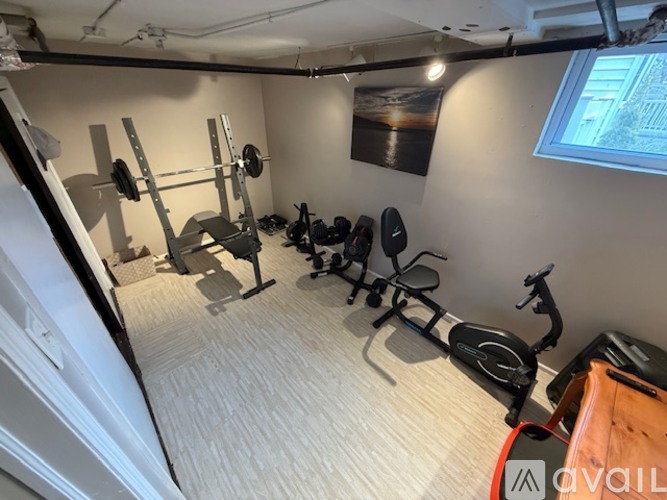 A home gym with a variety of equipment including a treadmill, weights, and a bench press.