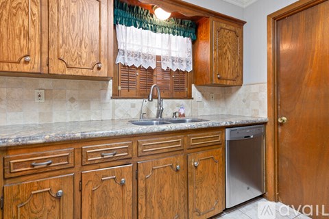 A kitchen with wooden cabinets and a granite countertop.