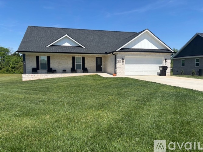 A house with a black roof and white walls is for sale.