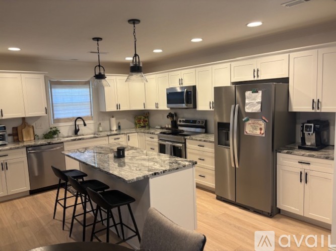 A kitchen with a marble countertop and stainless steel appliances.
