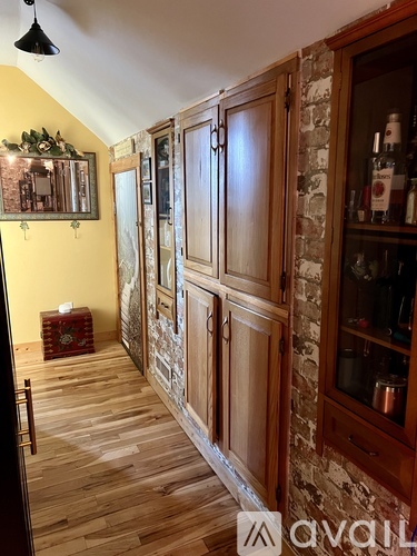 A hallway with wooden floors and a stone wall.
