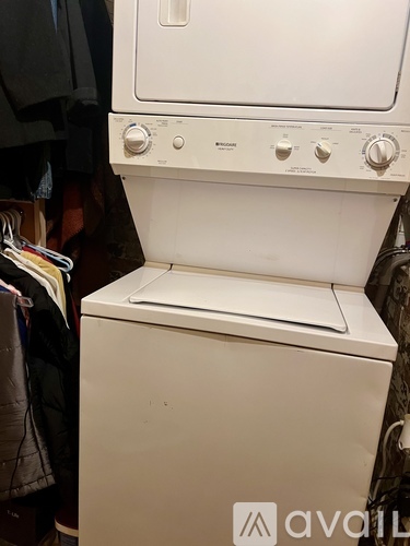A white washing machine with a dryer on top of it.