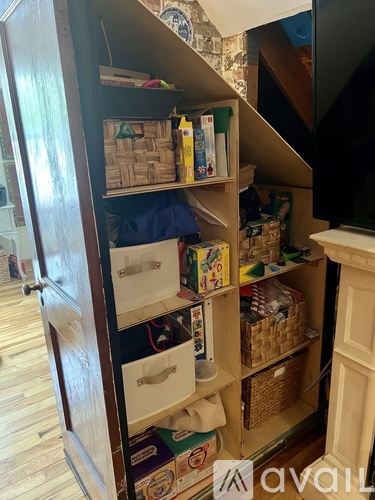 A wooden cabinet with many boxes and baskets on the shelves.