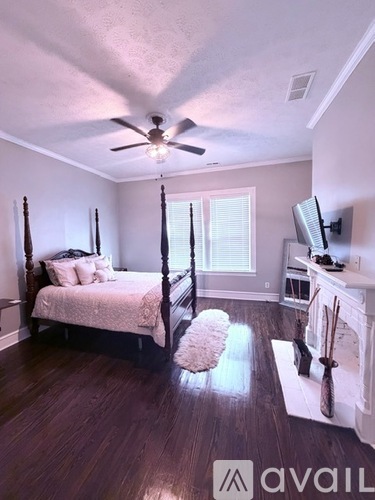 A bedroom with a four poster bed and a television.
