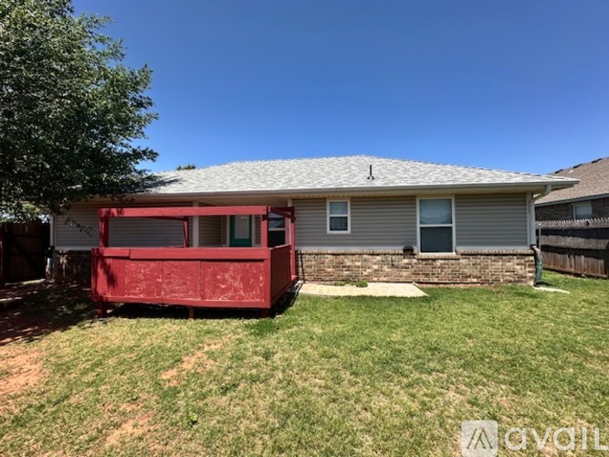 A house with a red awning is situated in a grassy area.