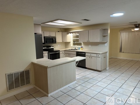 A kitchen with white cabinets and appliances.