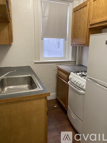 A kitchen with a stove, sink, and cabinets.