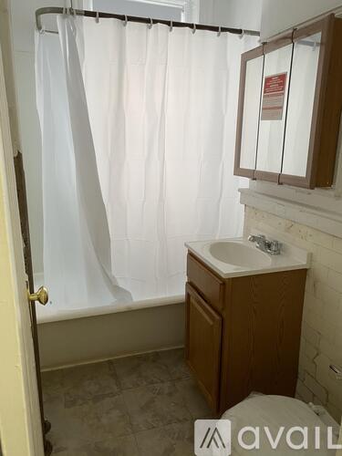 A bathroom with a white shower curtain and a white sink.