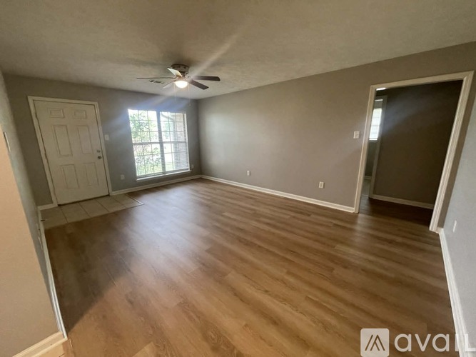 A room with wooden flooring and a ceiling fan.